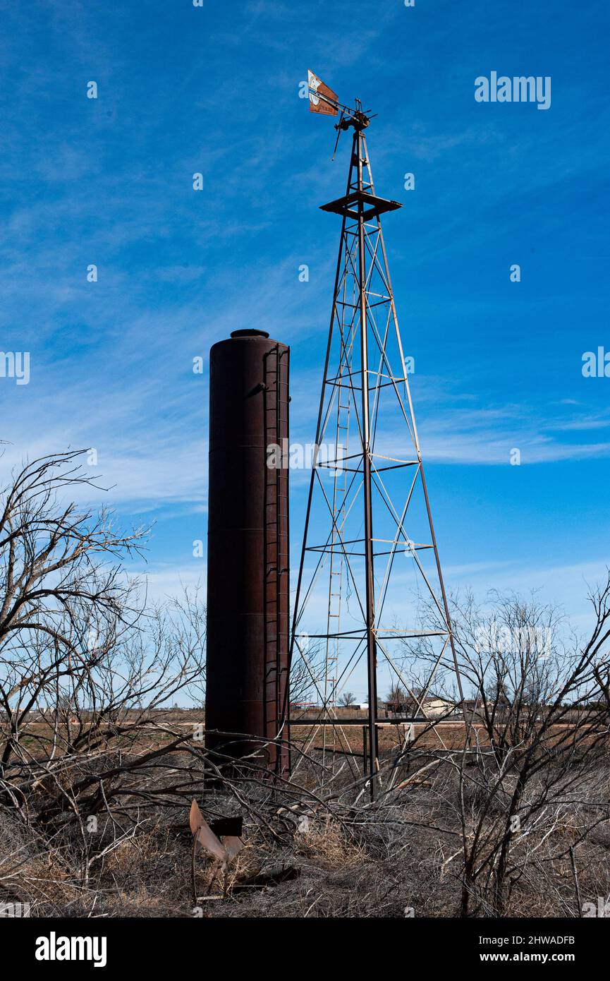 Altes Ackerland mit großem Silo und einer hohen Windmühle im ländlichen New Mexico. Stockfoto