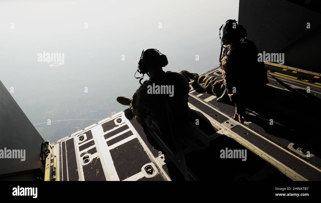 Zwei Flugzeugwarter, die dem Special Operations Aircraft Maintenance Squadron 353., dem Special Operations Wing 353., zugewiesen sind, beobachten thailändische und US-amerikanische Spezialeinsatzkräfte, die am 23. Februar 2022 als Teil von Cobra Gold 2022 über die Provinz Lopburi des Königreichs Thailand kommen. CG 22 ist die 41.. Auflage der internationalen Trainingsübung, die die Bereitschaft unterstützt und die Koordinierung bei zivilem Handeln, humanitärer Hilfe und Katastrophenhilfe betont. Vom 22. Februar bis zum 4. März 2022 findet diese jährliche Veranstaltung an verschiedenen Orten im Königreich Thailand in statt Stockfoto