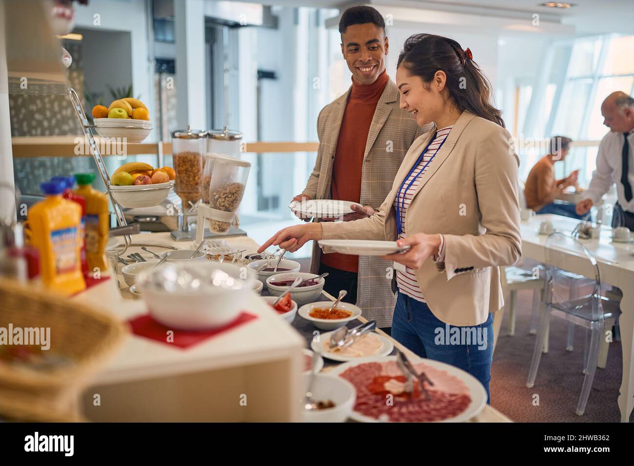 Junge Geschäftsleute genießen in der Kantine in entspannter Atmosphäre köstliche Speisen in Selbstbedienung. Unternehmen, Mitarbeiter, Unternehmen Stockfoto