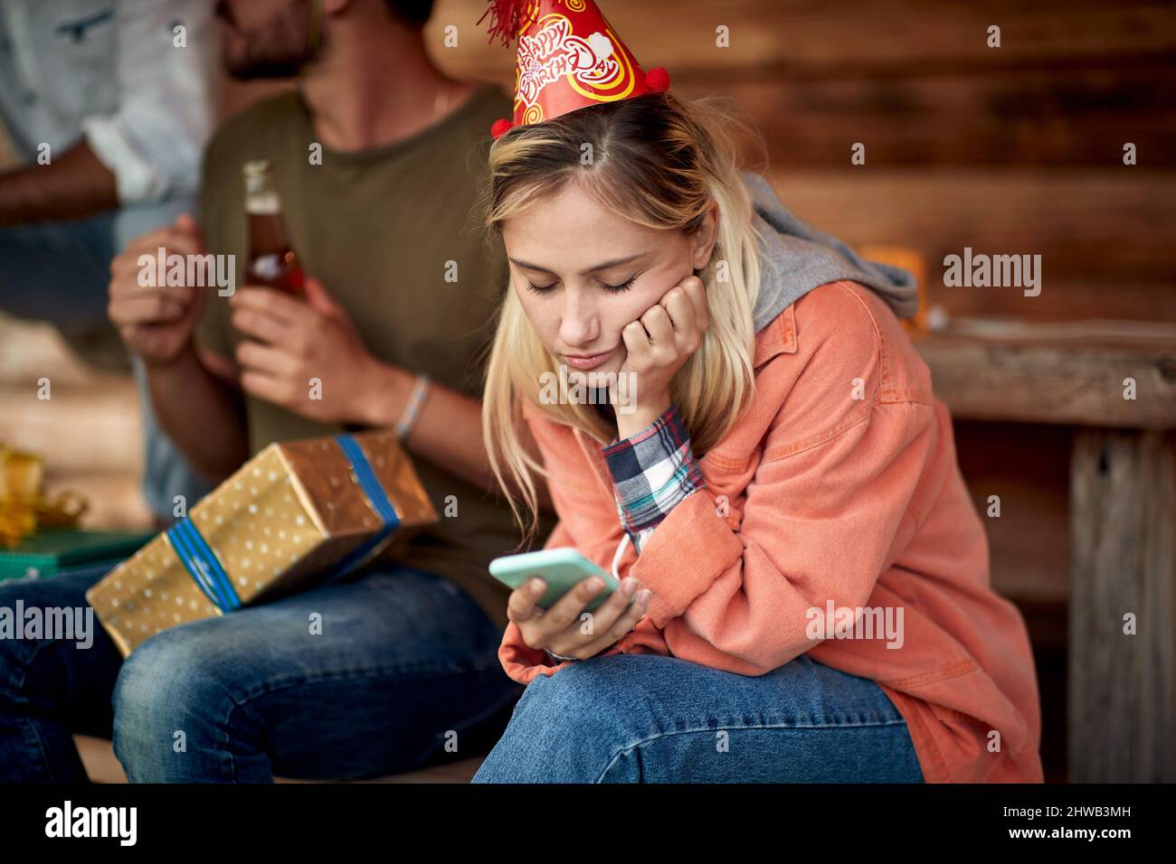 Mädchen fühlen sich auf Geburtstagsfeier gelangweilt. Sitzen und Telefonieren betrachten. Geburtstag, Feier, Feiertag. Stockfoto