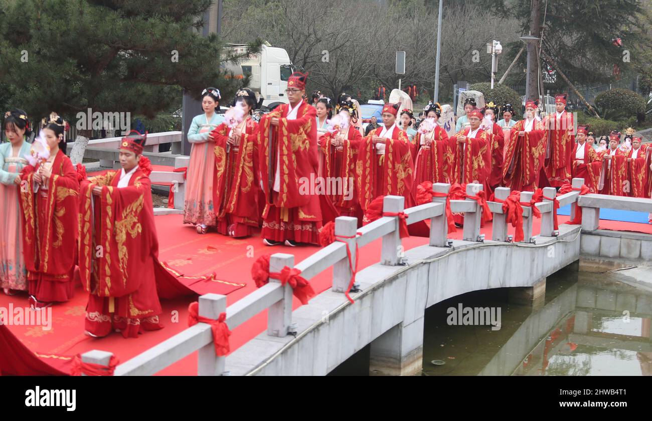 GUIYANG, CHINA - 5. MÄRZ 2022 - 20 Paare in traditionellen Han-Brautkleidern gehen in Guiyang, Guizhou Provin, zu ihrer Hochzeitszeremonie Stockfoto