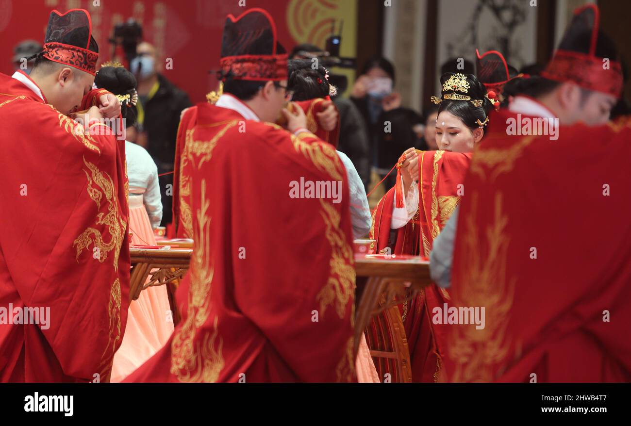 GUIYANG, CHINA - 5. MÄRZ 2022 - zwanzig Paare, die traditionelle Hochzeitskleidung im Han-Stil tragen, nehmen an ihrer Hochzeitszeremonie in Guiyang, Guizhou Provin, Teil Stockfoto