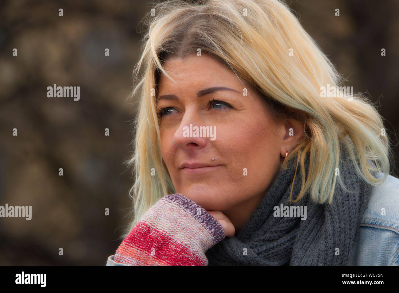 Porträt einer blonden Frau mit blauen Augen, die wegschaut Stockfoto