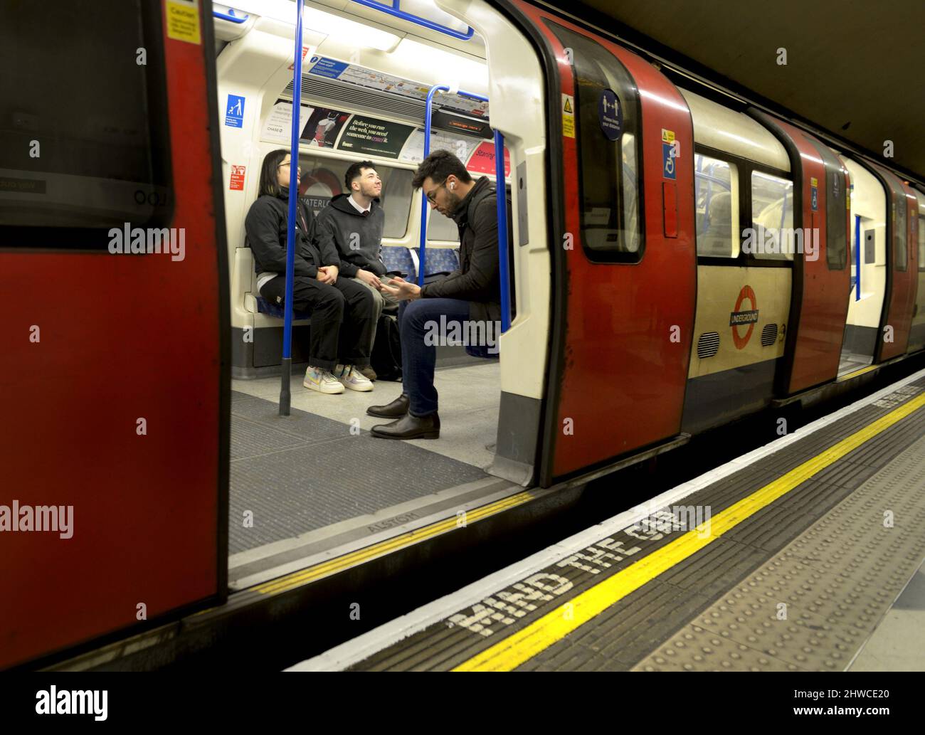 London, England, Großbritannien. Öffnen Sie die Tür des U-Bahn-Zuges mit den Fahrgästen im Inneren und beachten Sie die Gap-Warnung auf dem Bahnsteig Stockfoto