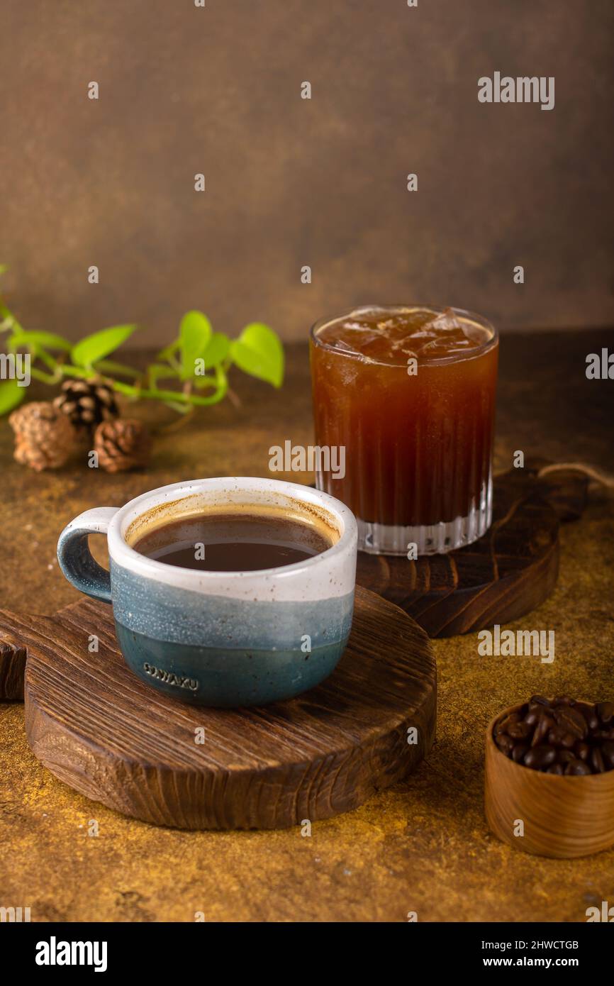 Ein aromatischer Kaffee, der frisch zum Ausgießen gemahlen wird, wird auf einem rustikalen Holztablett zu heißem oder kaltem schwarzen Kaffee Stockfoto