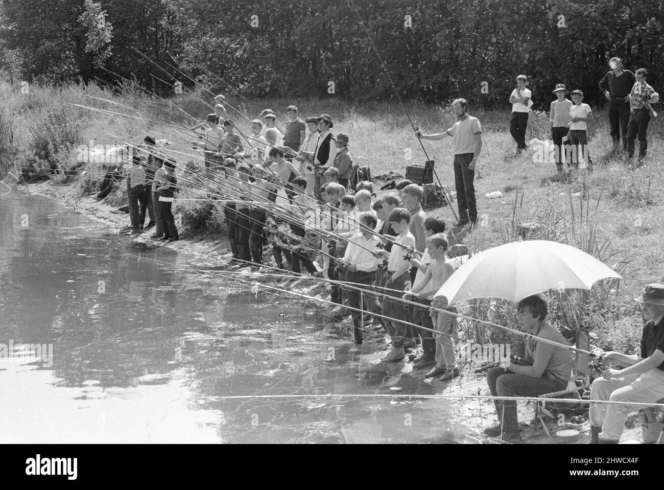 Achten Sie auf Fische! Eine Gruppe von Jungen im Alter zwischen zehn und vierzehn Jahren gesehen hier in Wraysbury, Buckinghamshire wird gelehrt, wie man Fisch. Es war Teil einer Veranstaltung, die vom Londoner und dem südostöstlichen Tackle Dealer organisiert wurde, um den Jugendlichen einige der Feinheiten des Süßwasserfischens zu zeigen. 13.. Juli 1970 Stockfoto
