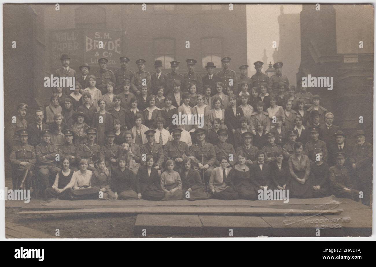Futterkomitee, Priestley Hall, Leeds, Januar 1919. Gruppenfoto einer großen Anzahl von Männern und Frauen, die überwiegende Mehrheit der Männer sind in Armeeuniform. Auf dem Gebäude dahinter steht eine Werbetafel für S. M. Bryde & Co, Ltd., Tapetenhersteller. Das Frauenfrauenkorps unterstützte den Transport und die Versorgung von Pferden während des Ersten Weltkriegs Stockfoto