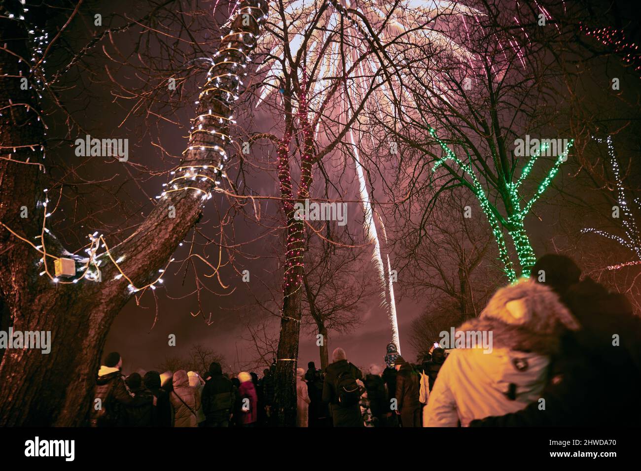 Paar umarmen und beobachten das Neujahrsfeuerwerk und das Mädchen, das am Telefon auf dem Primorsky Boulevard in Odessa in der Ukraine schießt Stockfoto