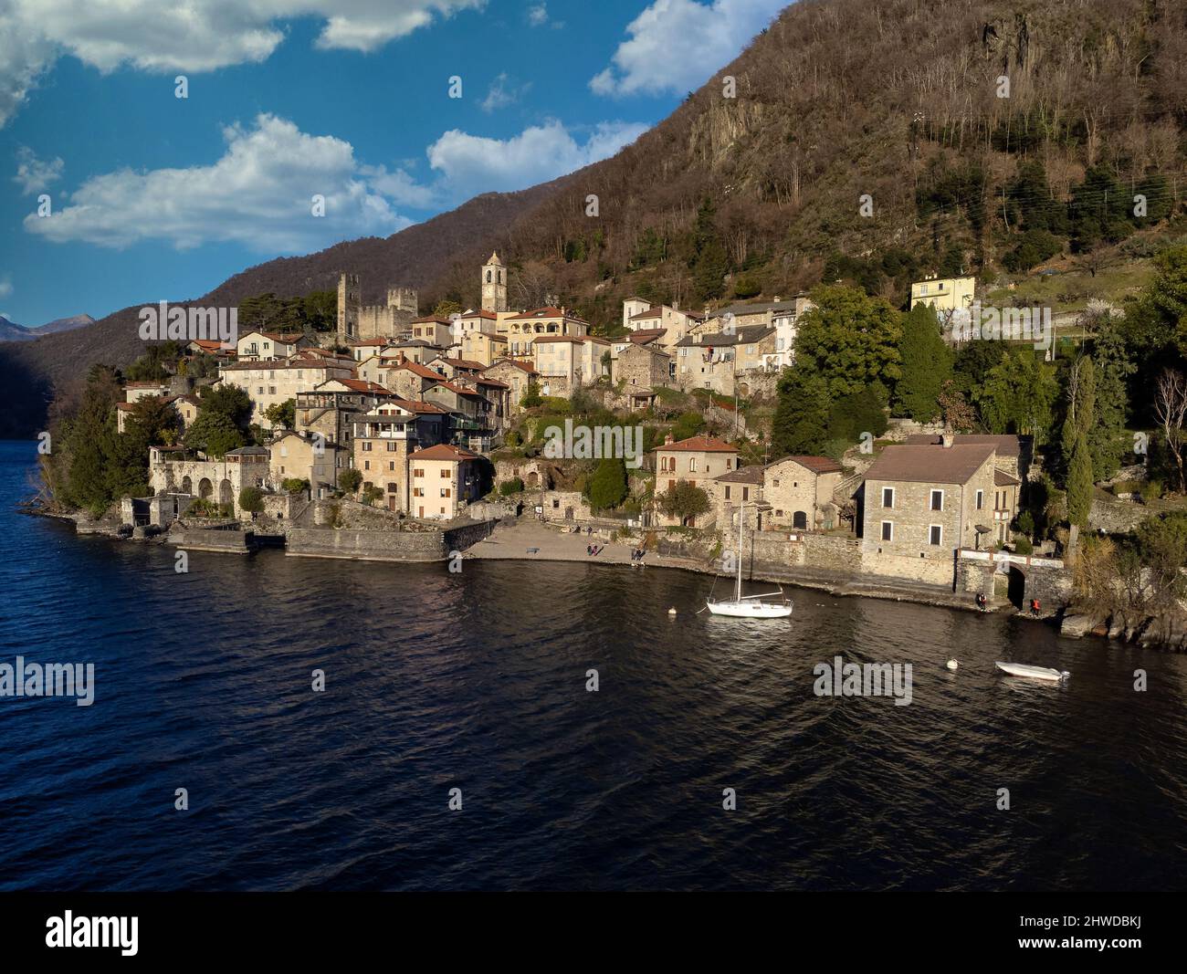 LUFTAUFNAHME. Panoramafild, Postkartenansicht vom See eines kleinen alten Dorfes in der Lombardei, Comer See Region, Italien Stockfoto