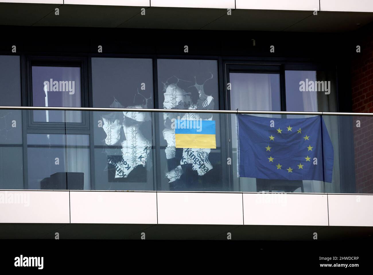 Flaggen der Europäischen Union und der Ukraine auf einem Balkon in einem Appartementblock mit Blick auf den Golfplatz auf der Rennbahn Newbury Racecourse, Bekshire. Bilddatum: Samstag, 5. März 2022. Stockfoto