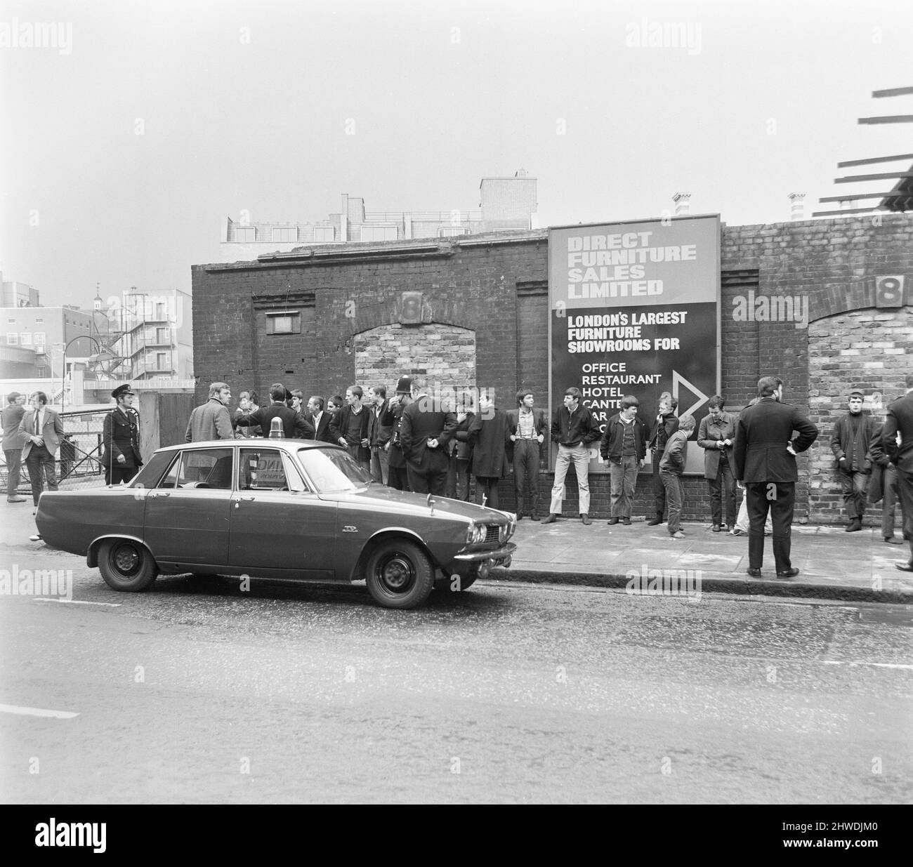 Skinheads treffen sich in der Farringdon Road, London. Zwanzig bis dreißig Jugendliche wurden entlang der Farringdon Road verfolgt, nachdem sie einen verbebten Zug und einen angeblichen Angriff auf einen Mann verübt hatten. Die Häupter wurden angehalten und mussten ihre Stiefel ausziehen, während die Polizei sie an einer Wand anstellte und sie durchsuchte. Bild zeigt: Jugendliche stehen an der Wand, während die Polizei Ermittlungen anstellt. 4.. April 1970. Stockfoto
