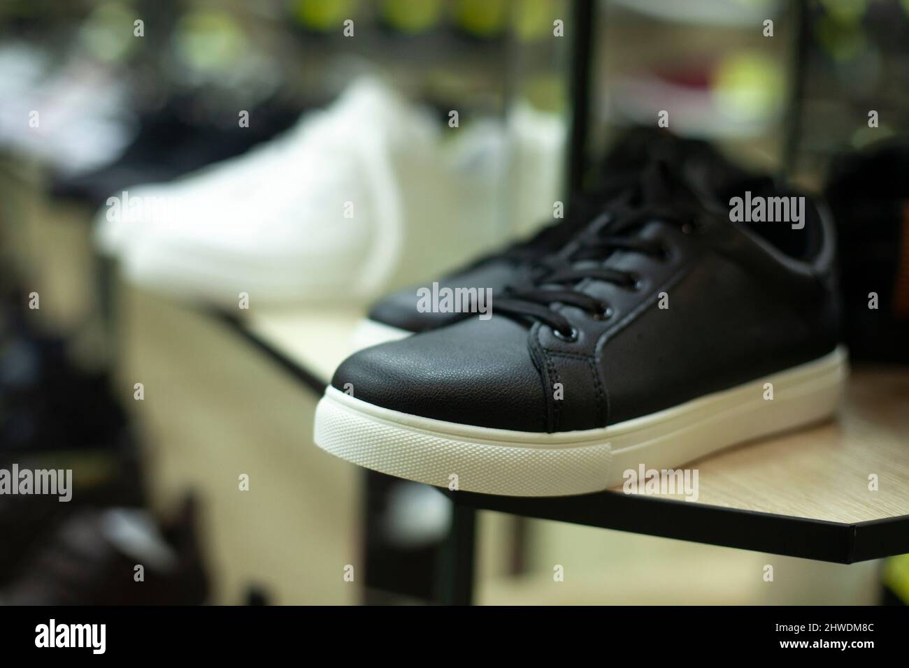 Schuhe auf der Theke. Stiefel werden im Laden verkauft. Herren Sneaker für den Sommer. Details des Innenraums des Handelsgeschosses. Dinge in den Regalen. Stockfoto