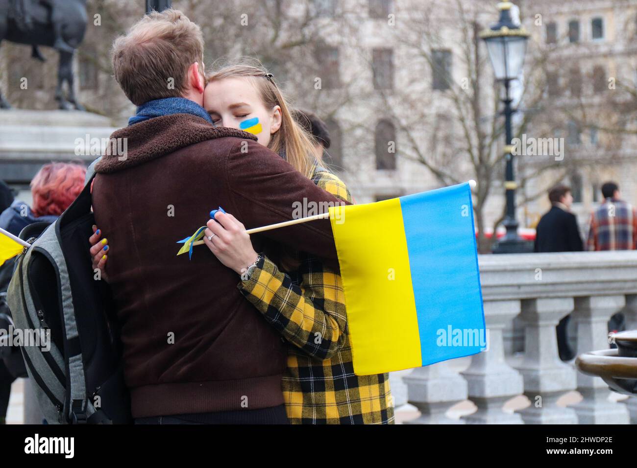 LONDON, 05 2022. MÄRZ, Demonstranten mit ukrainischer Flagge umarmt während eines Protestes gegen die russische Invasion in der Ukraine auf dem Trafalgar Square Credit: Lucy North/Alamy Live News Stockfoto