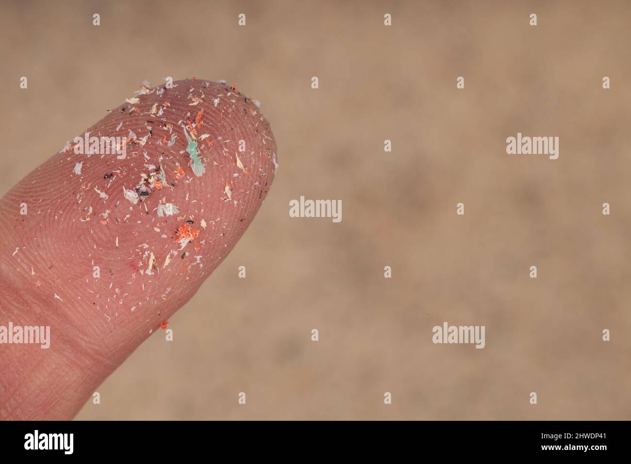 Nahaufnahme von Mikroplastik lag auf dem Finger des Menschen. Konzept der Wasserverschmutzung und der globalen Erwärmung. Idee für den Klimawandel. Stockfoto