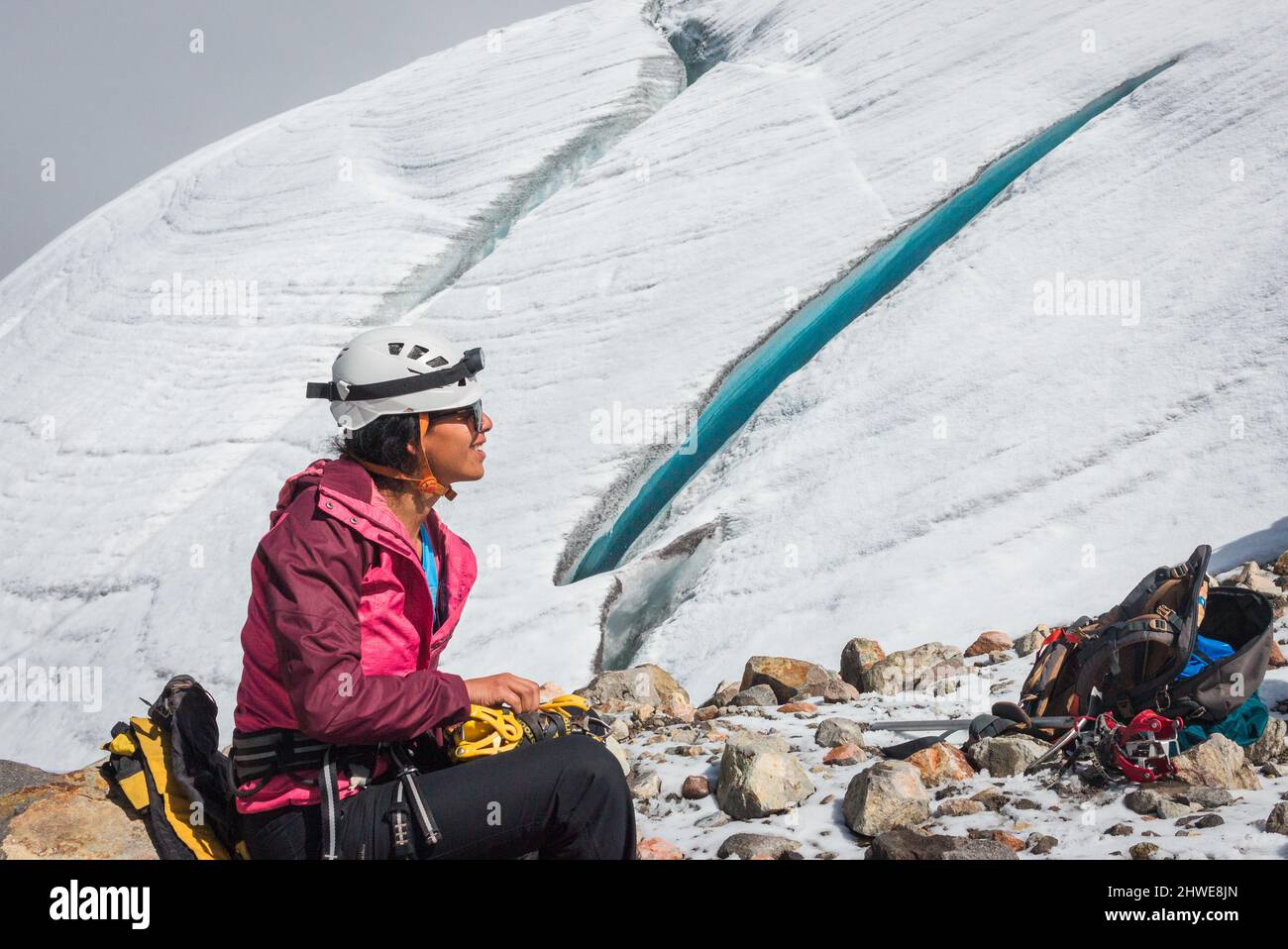 Schöne lateinerin lächelt natürlich beim Wandern vor einer Gletscherspalte (Riss) Stockfoto