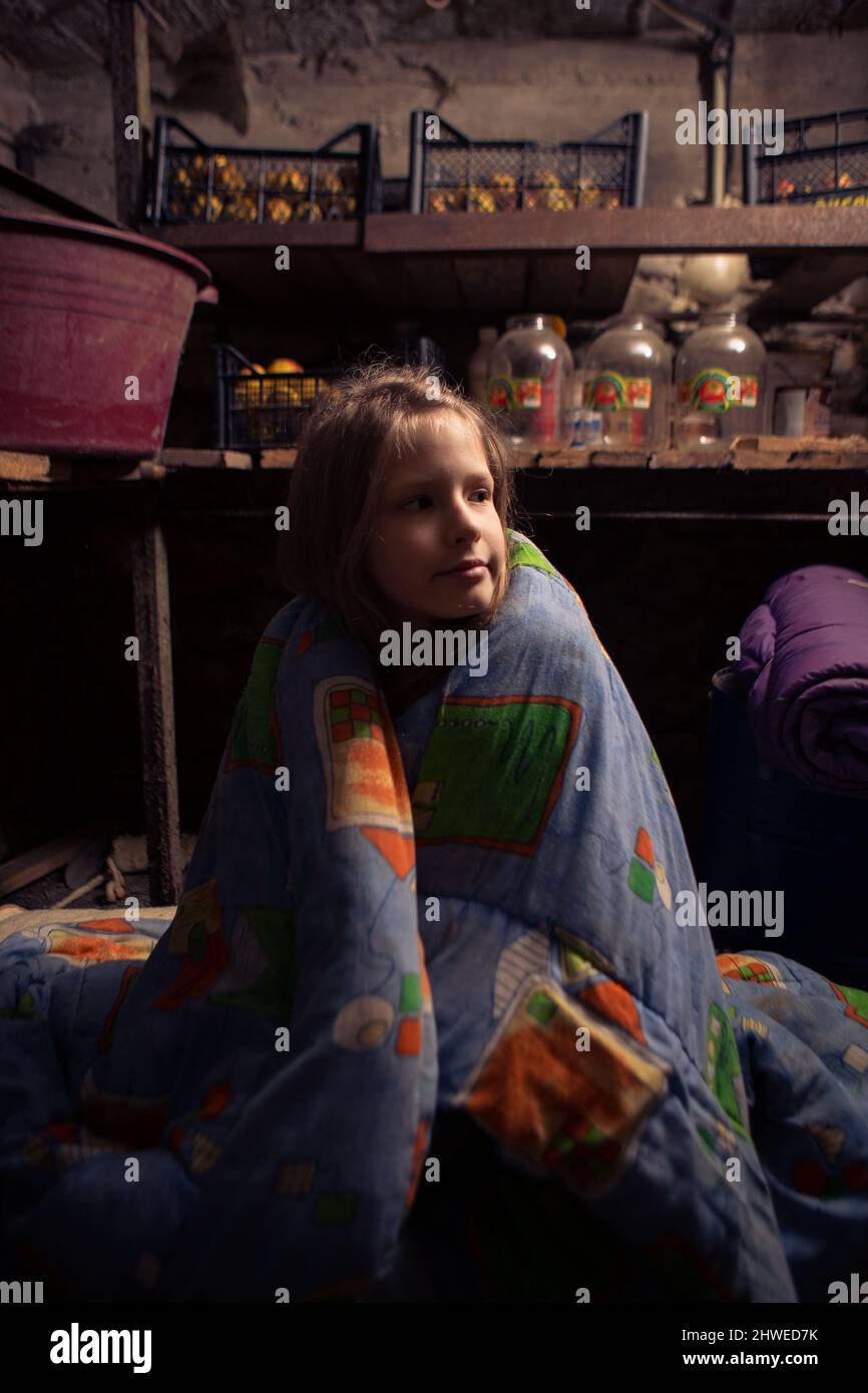 Ukrainisches Mädchen nimmt in ihrem Keller Schutz. Krieg beenden. Stockfoto