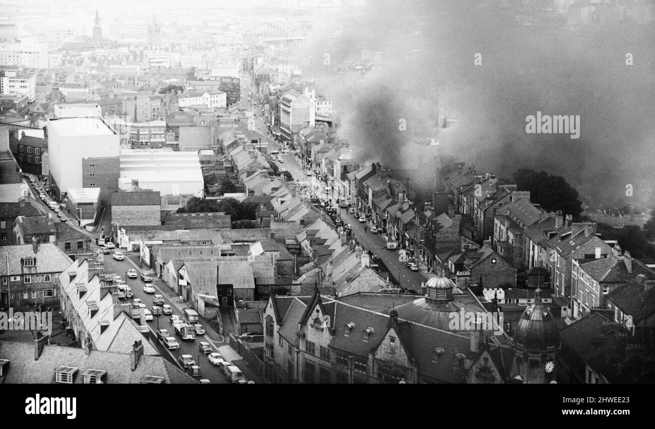 Feuer im Firestone-Reifenlager, Westgate Hill, Newcastle. 31.. Juli 1969Families das Leben in der Nähe musste evakuiert werden, als der gesamte Gebäudekomplex in Flammen aufging. In einer Phase griffen 56 Feuerwehrleute und 15 Feuergeräte den riesigen Brand an. Dichter Rauch stieg in den Abendhimmel und konnte so weit entfernt wie South Shields und Ponteland gesehen werden. Auf der Höhe der brennenden Farben- und Fettdosen in einem Lagerraum explodierten und schlugen auf das Dach und schickten Fliesen und Schiefer 100ft in die Luft, aber die Menschen drängten sich immer noch auf die Straße, um zu sehen, was los war. Stockfoto