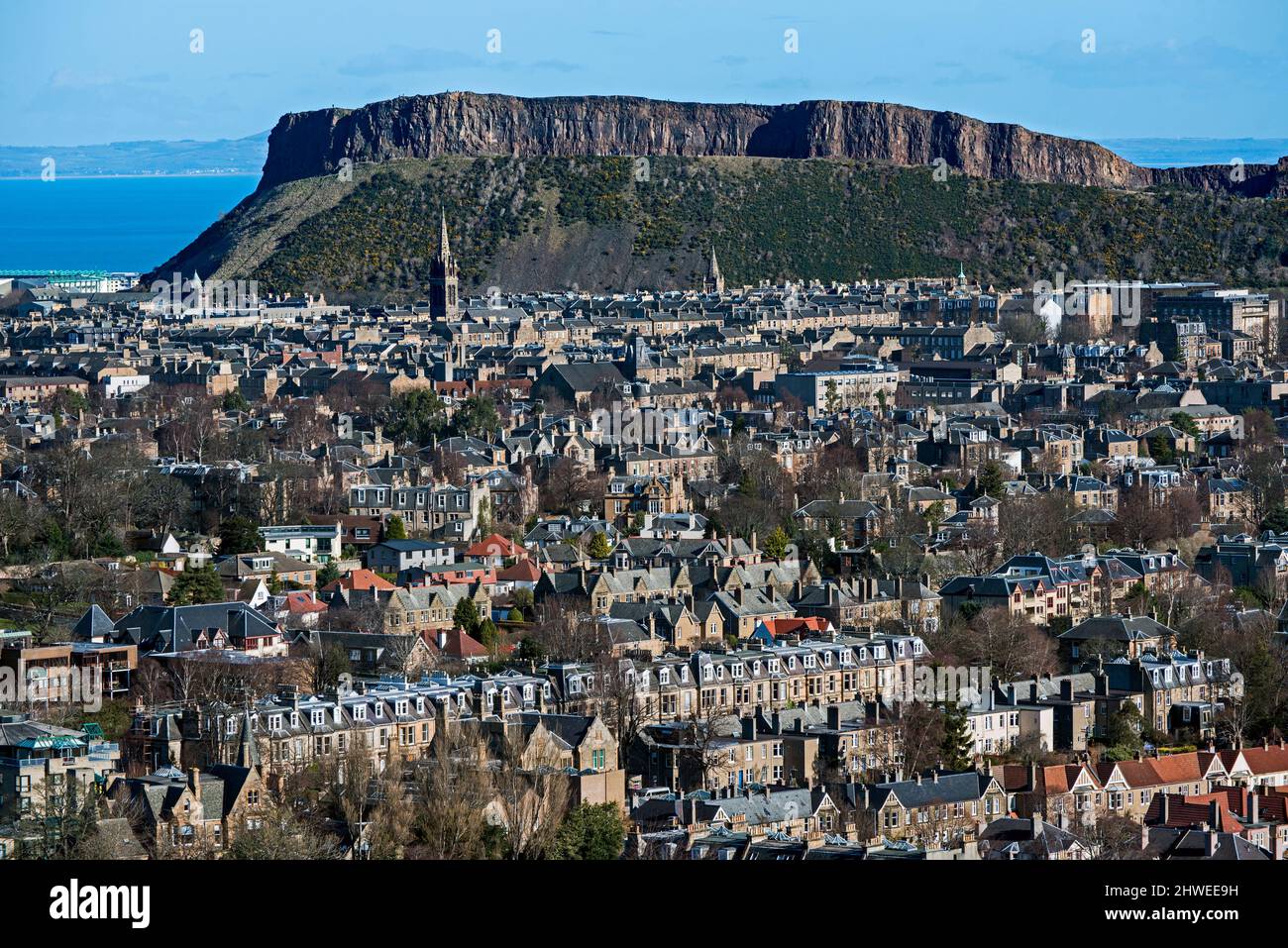 Wohnhäuser in Süd-Edinburgh mit Salisbury Crags im Hintergrund, aufgenommen aus Blackford Hill, Edinburgh, Schottland, Großbritannien. Stockfoto