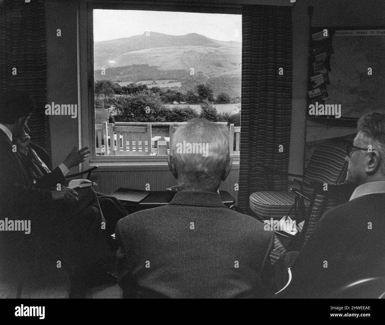 Brecon Beacons Mountain Center, Brecon, Powys, Mid Wales, Donnerstag, 3.. September 1970. Zimmer mit Aussicht. Besucher bewundern die Szene durch das Fenster, einen Blick auf Pen y Fan und Corn Du, die beiden höchsten Punkte in den Leuchttürmen. Stockfoto