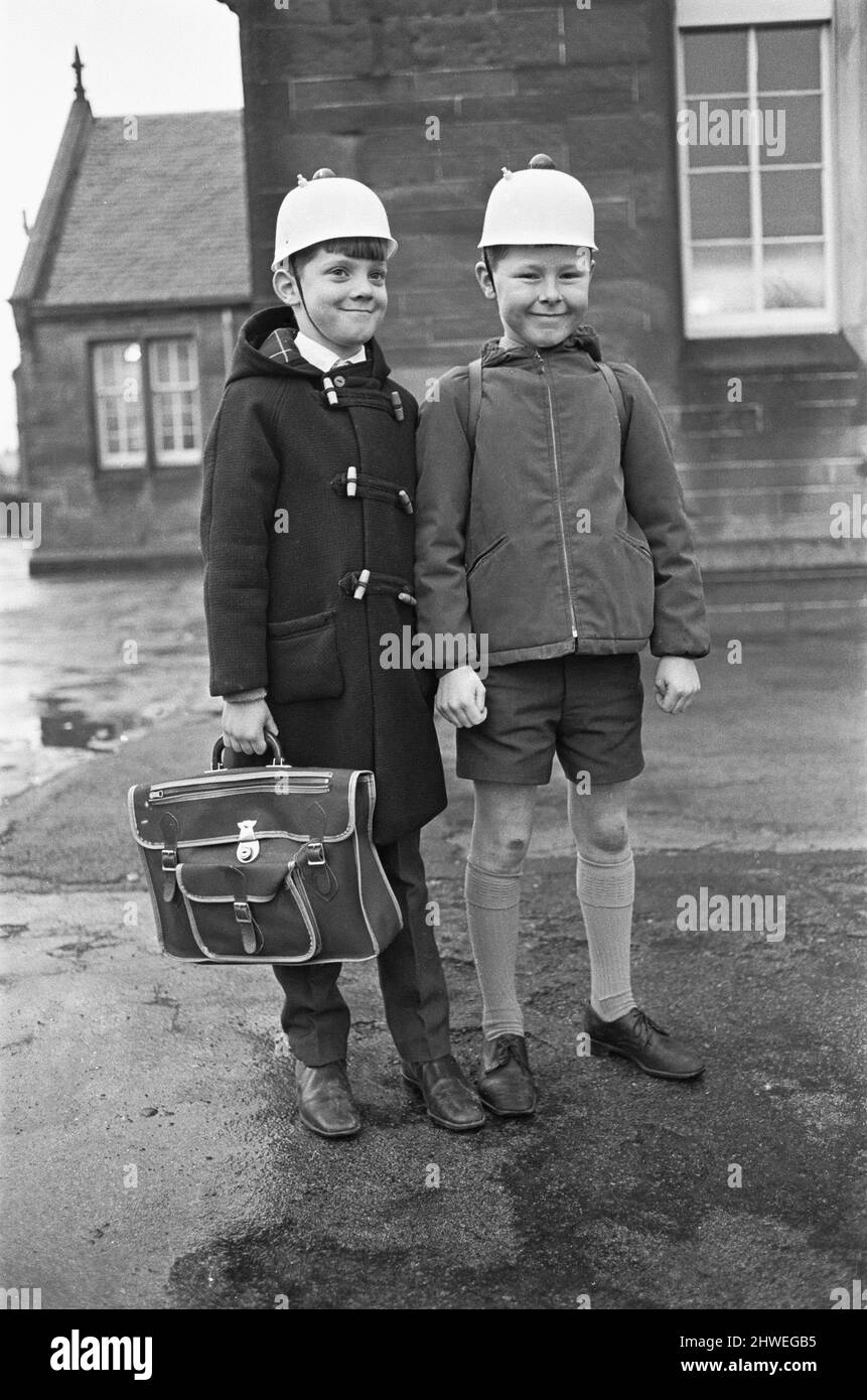 Gute Idee! Zwei Schüler von Hamilton sahen hier, wie sie die neueste Sicherheitskopfbedeckung modelliert haben, einen blinkenden Helm, um den Autofahrern zu zeigen, dass Kinder die Straße überqueren. 3.. Januar 1970 Stockfoto