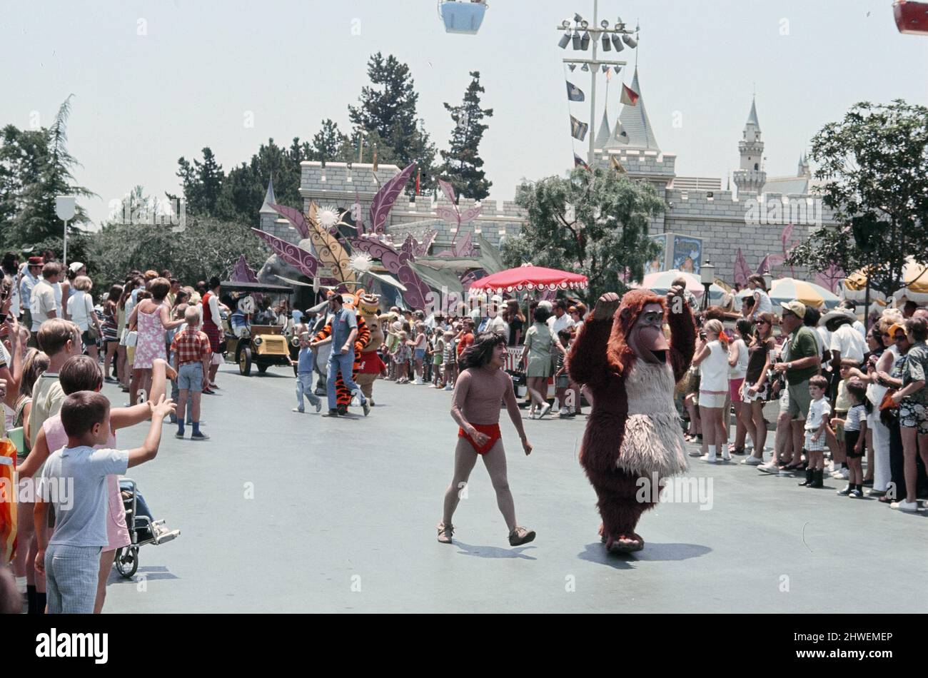 Szenen im Disneyland Themenpark in Anaheim, Kalifornien, USA. Die Dschungelbuchfiguren Mowgli und Baloo während der Main Street Parade. Juni 1970. Stockfoto