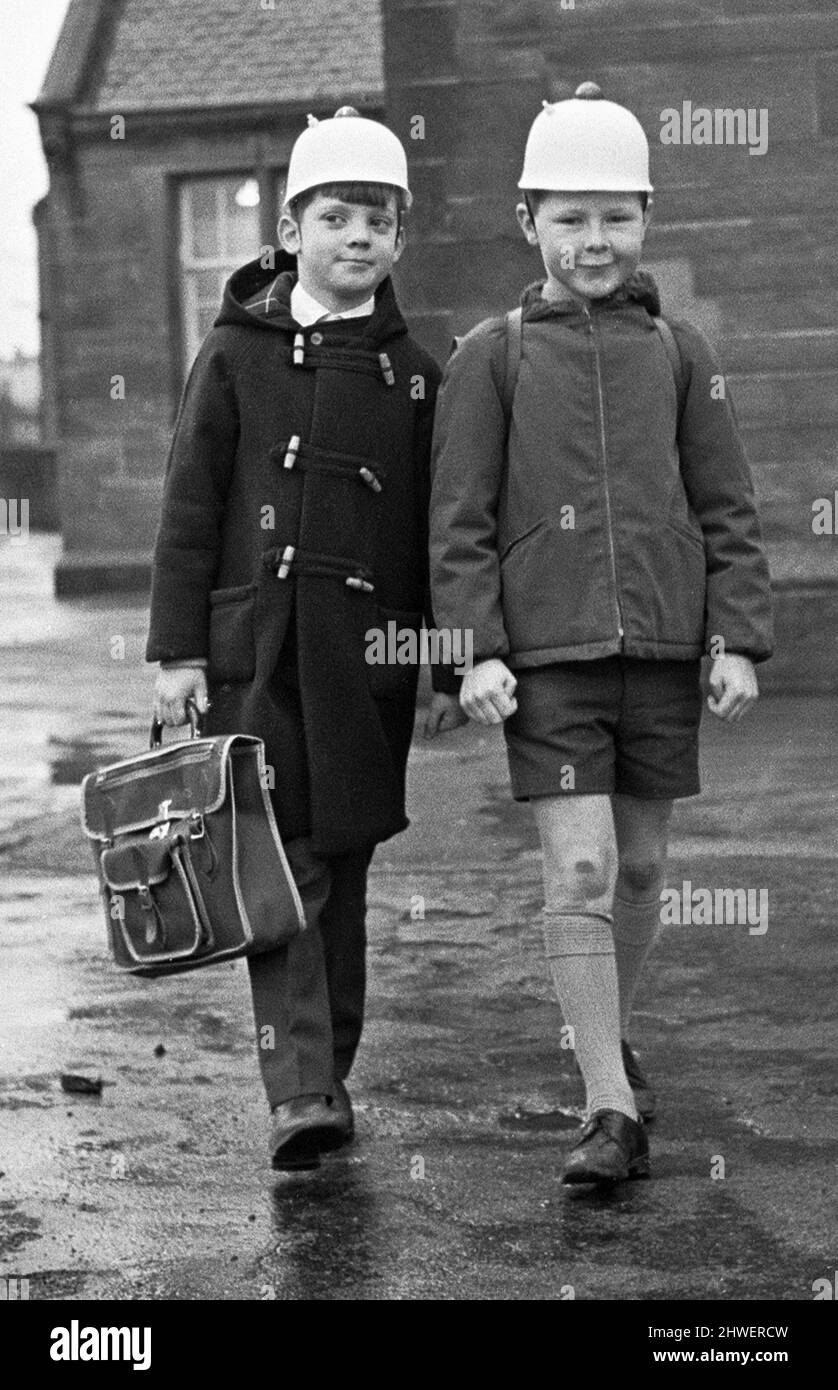 Gute Idee! Zwei Schüler von Hamilton sahen hier, wie sie die neueste Sicherheitskopfbedeckung modelliert haben, einen blinkenden Helm, um den Autofahrern zu zeigen, dass Kinder die Straße überqueren. 3.. Januar 1970 Stockfoto