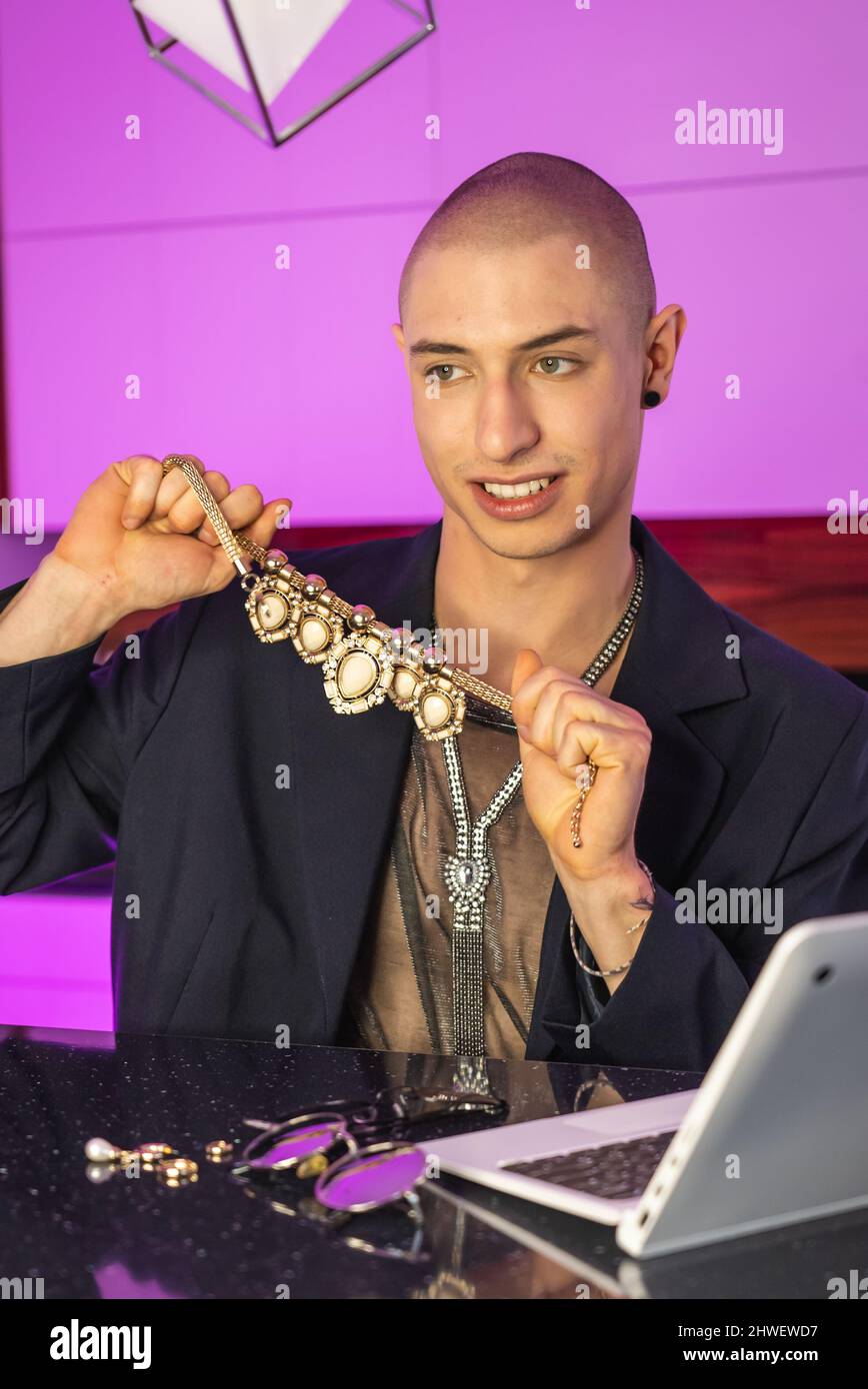 In seinem neuen Video zeigt der modische schwule Influencer seinen Anhängern seine gesamte Schmuckkollektion und spricht über Modetrends. Vertikales Foto. Hochwertige Fotos Stockfoto