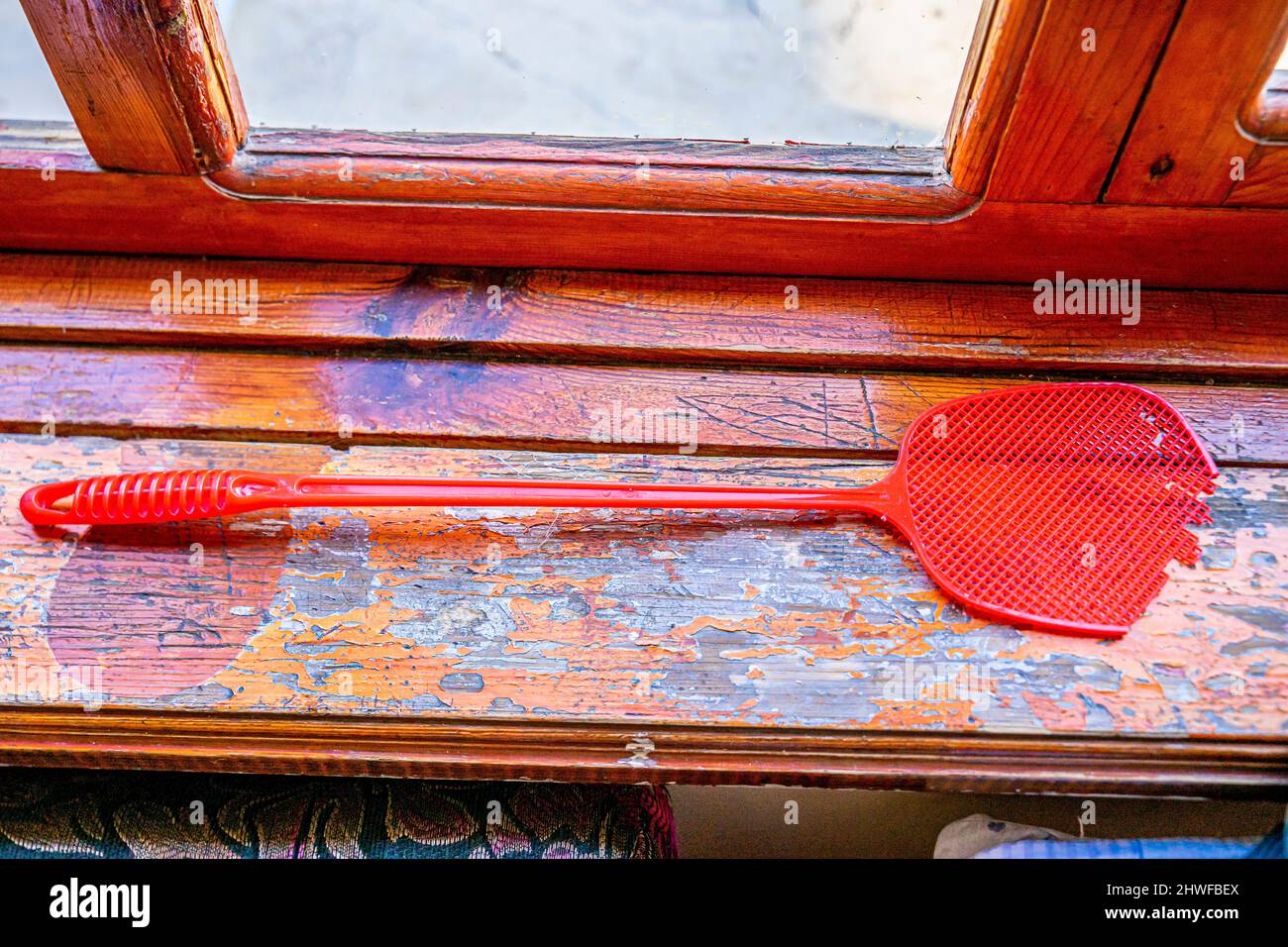 Rote Plastikfliegenspritzer auf der Windosschwelle. Turkistan, Kasachstan Stockfoto
