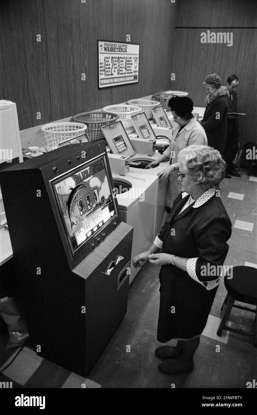 In der Waschküche in der Warwick Road, Banbury, Oxon, wurde ein Spielautomat installiert. Auf dem Bild probiert Frau Violet Cox ihre Hand gegen den bewaffneten Banditen. Die Maschine zahlt Wertmarken aus, mit denen die Waschmaschinen bedient werden können. Wenn das nicht so gut ist, können Sie die Token im Crown Inn Pub nebenan gegen ein Getränk eintauschen. Dem Vermieter Charlie Williamson gehört auch der Waschsalon. 16.. Januar 1969. Stockfoto