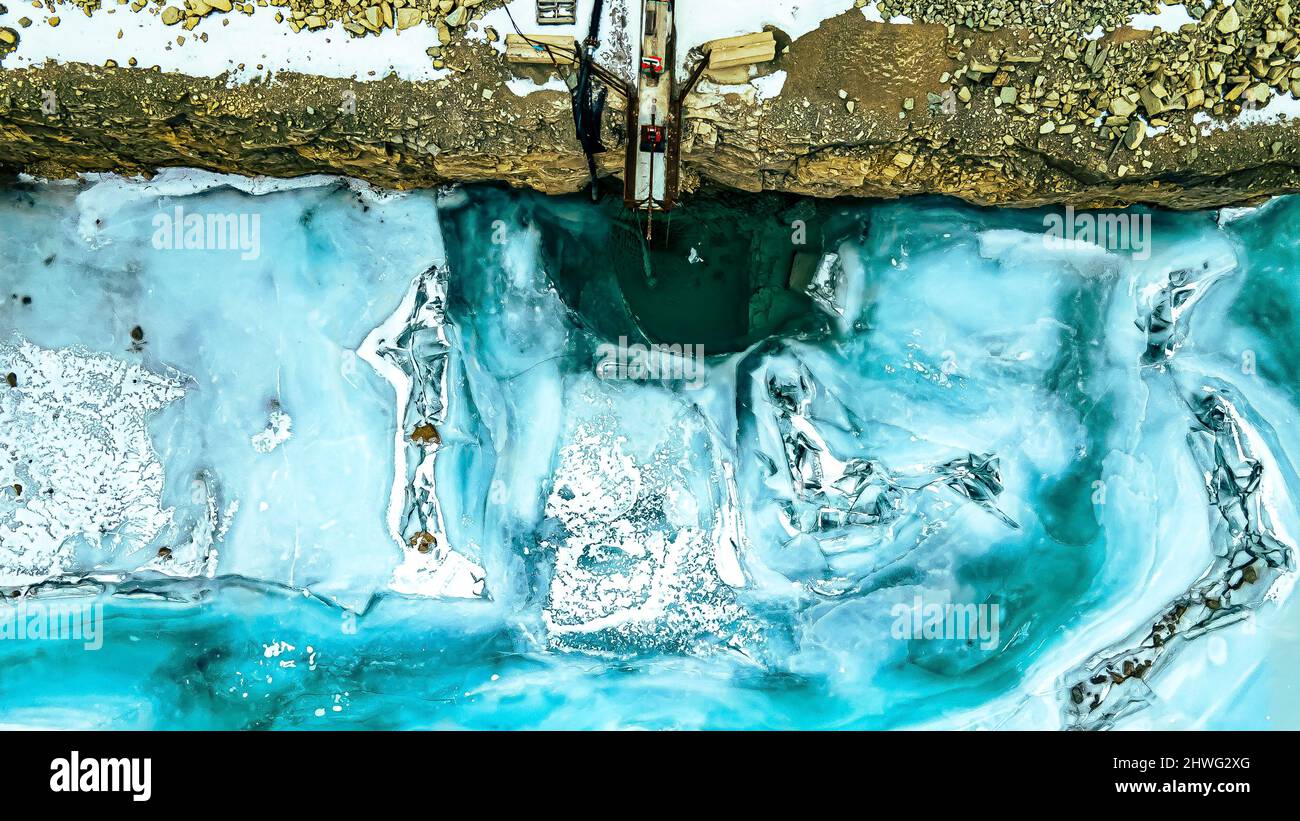 Das in einem Steinbruch stehende Wasser erstarrte tief in der Schlucht des Steinbruchs in einen wunderschönen blauen Schatten. Stockfoto