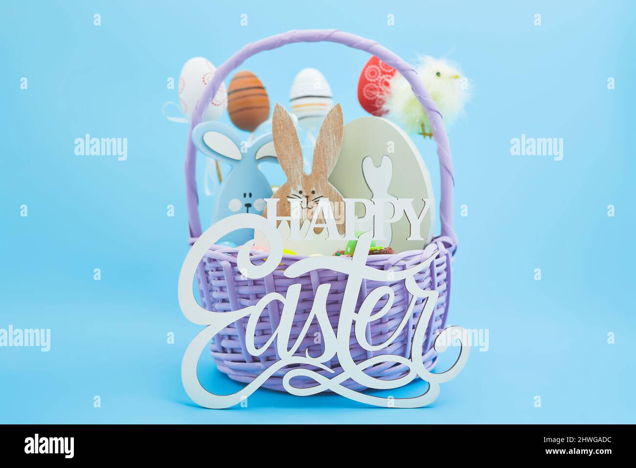 Weißeier im Nest und gelbe Küken auf blauem Hintergrund. Eine Osterkarte mit einer Kopie des Ortes für den Text. Stockfoto