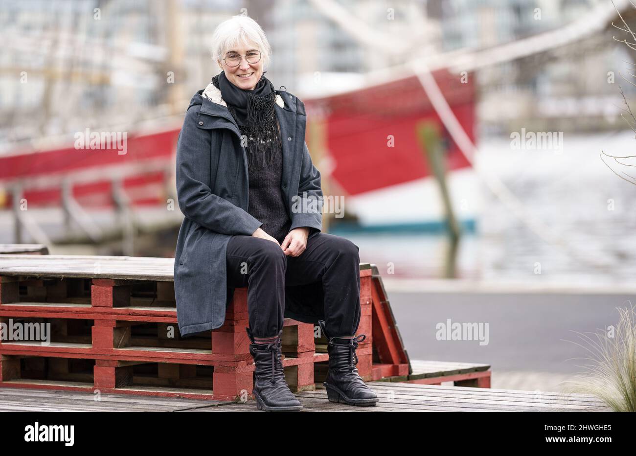 Flensburg, Deutschland. 22.. Februar 2022. Andrea Paluch, Schriftstellerin, Literaturwissenschaftlerin und Übersetzerin und Ehefrau des Politikers Robert Habeck, sitzt am Museumshafen der Flensburger Förde. (To dpa: 'Weltende und Sinnsuche - die Schriftstellerin Andrea Paluch') Quelle: Axel Heimken/dpa/Alamy Live News Stockfoto