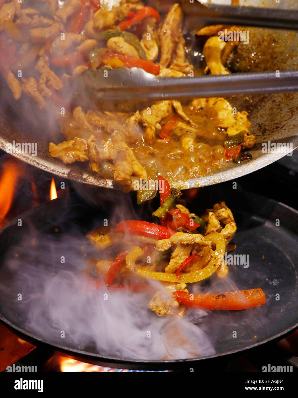 mexikanische authentische Speisen, Huhn Fajitas auf einem heißen rauchenden brutzelnden Teller serviert Stockfoto