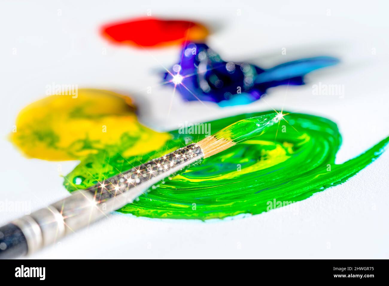 Glänzende Kunst und Handwerk Thema zeigt einen Pinsel und einige bunte Farbe in Licht zurück Stockfoto