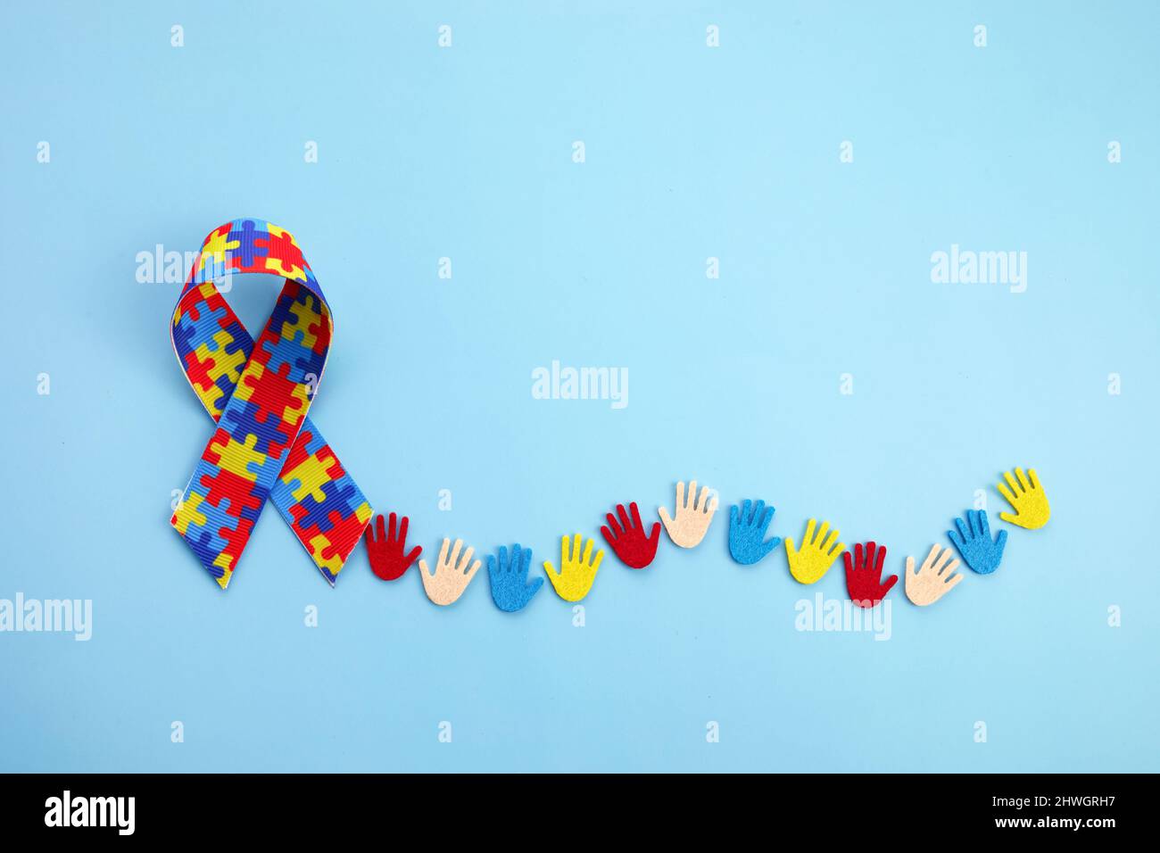 Autismus-Bewusstsein-Konzept mit bunten Händen auf blauem Hintergrund. Draufsicht Stockfoto