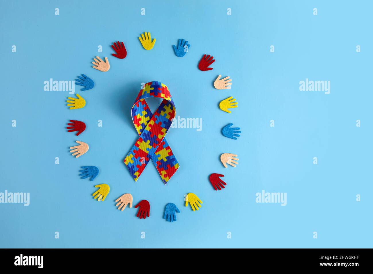 Autismus-Bewusstsein-Konzept mit bunten Händen auf blauem Hintergrund. Draufsicht Stockfoto