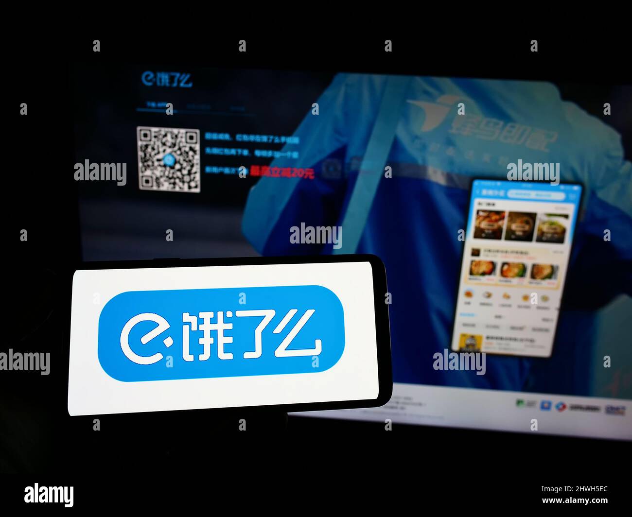 Person, die das Smartphone mit dem Logo des chinesischen Lebensmittellieferungsunternehmens ELEME Inc. (Ele.me) auf dem Bildschirm vor der Website hält. Konzentrieren Sie sich auf die Telefonanzeige. Stockfoto