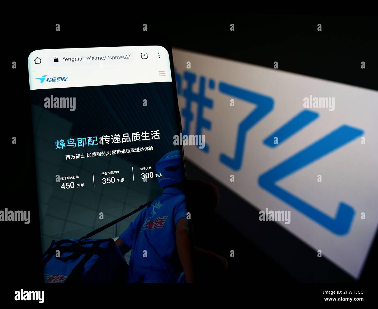 Person mit Smartphone und Webseite des chinesischen Lebensmittellieferungsunternehmens ELEME Inc. (Ele.me) auf dem Bildschirm mit Logo. Konzentrieren Sie sich auf die Mitte des Telefondisplays. Stockfoto
