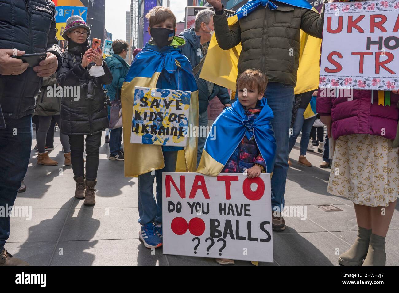New York, Usa. 05. März 2022. Vlad, 9 Jahre, und Jarek, 4 Jahre alt, mit ukrainischer Flagge gehüllt und mit Schildern versehen, nehmen an der „Stand with Ukraine“-Kundgebung am 5. März 2022 in New York City am Times Square Teil. Ukrainer, Ukrainer-Amerikaner und Verbündete versammelten sich, um Unterstützung für die Ukraine zu zeigen und gegen die russische Invasion zu protestieren. Kredit: SOPA Images Limited/Alamy Live Nachrichten Stockfoto