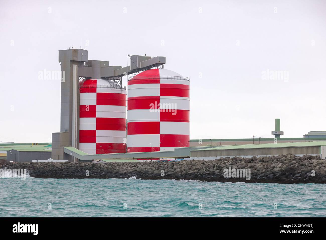 Rot-weiße Silotanks. Hafengebäude und Hangars, Hafen in Island Stockfoto