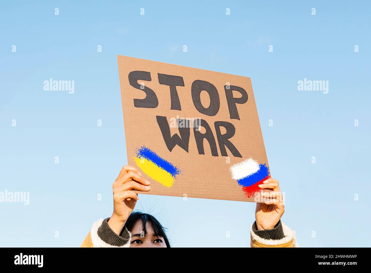 Junge asiatische Frau protestiert gegen die invasion der russischen Armee in die Ukraine Stockfoto