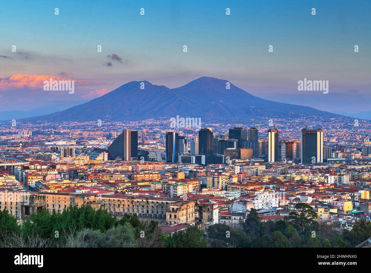 Neapel, Italien mit der Skyline des Finanzviertels unter dem Berg Vesuv in der Dämmerung. Stockfoto