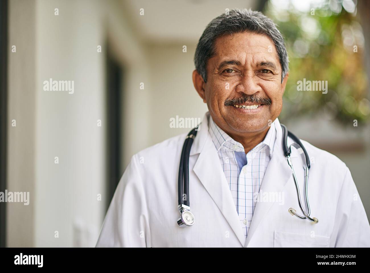 Freut sich, Ihnen bei der Genesung zu helfen. Porträt eines reifen männlichen Arztes, der draußen steht. Stockfoto