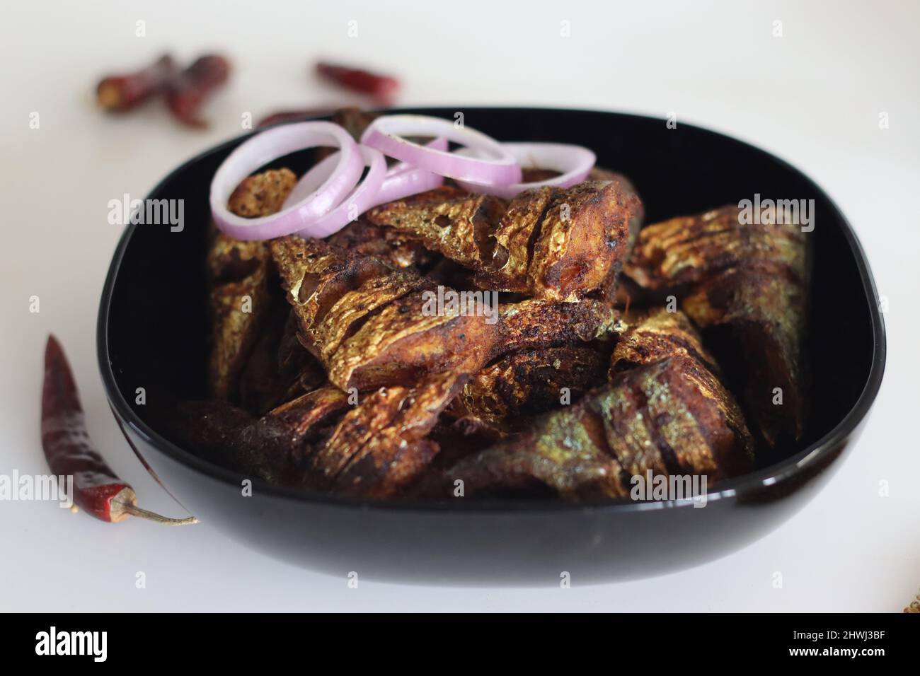 Marinierter und flacher gebratener Makrelenfisch. Eine beliebte, nicht vegetarische Beilage aus kerala-Mahlzeiten, die ayala-Fritte genannt wird. Aufgenommen auf weißem Hintergrund Stockfoto