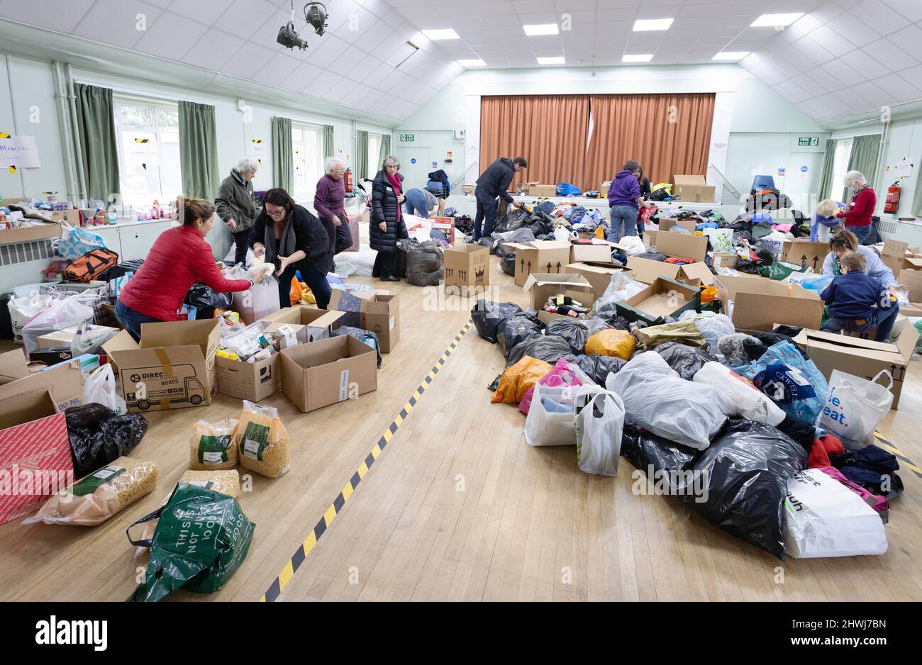 Kriegshilfe; Freiwillige, die wohltätige Spenden von Lebensmitteln und Kleidung für die Ukraine sortieren; der Ukraine-Russland-Krieg, 2022, Great Shelford Cambridgeshire UK Stockfoto