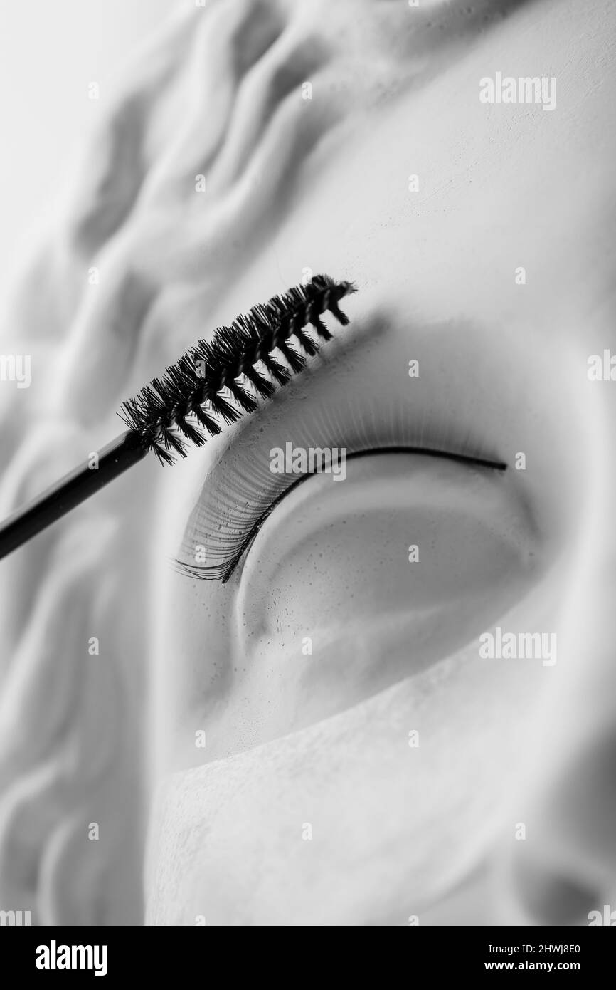 Minimalismus Konzept der Wimpern Verlängerung Verfahren, Mascara für Make-up auf antike Skulptur. Stockfoto