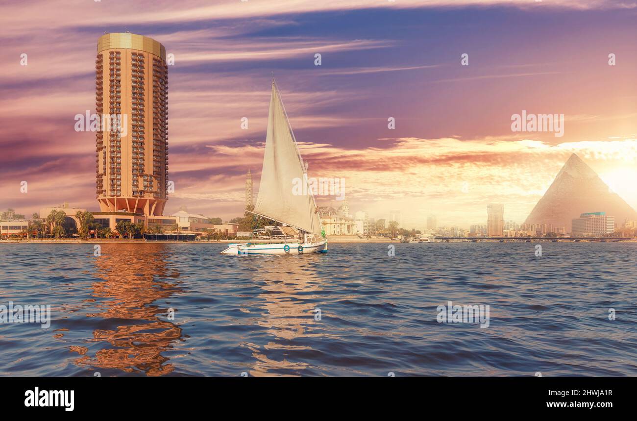 Sonnenuntergang Nil mit weißen Segelyacht Hintergrund ägyptische Pyramide Kairo, Ägypten. Stockfoto