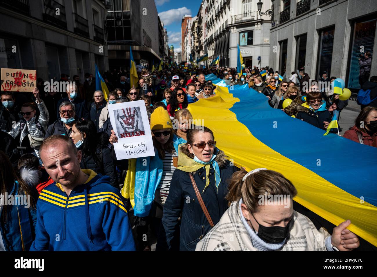 Madrid, Spanien. 06. März 2022. Demonstranten, die Plakate und ukrainische Flaggen tragen, werden während einer Demonstration gegen die russische Invasion in die Ukraine gesehen. In Madrid lebende Ukrainer und spanische Anhänger marschierten durch die Stadt und forderten das Ende des Krieges in der Ukraine, protestierten gegen den russischen Präsidenten Wladimir Putin und forderten von der NATO, den Himmel über der Ukraine zu schließen. Quelle: Marcos del Mazo/Alamy Live News Stockfoto