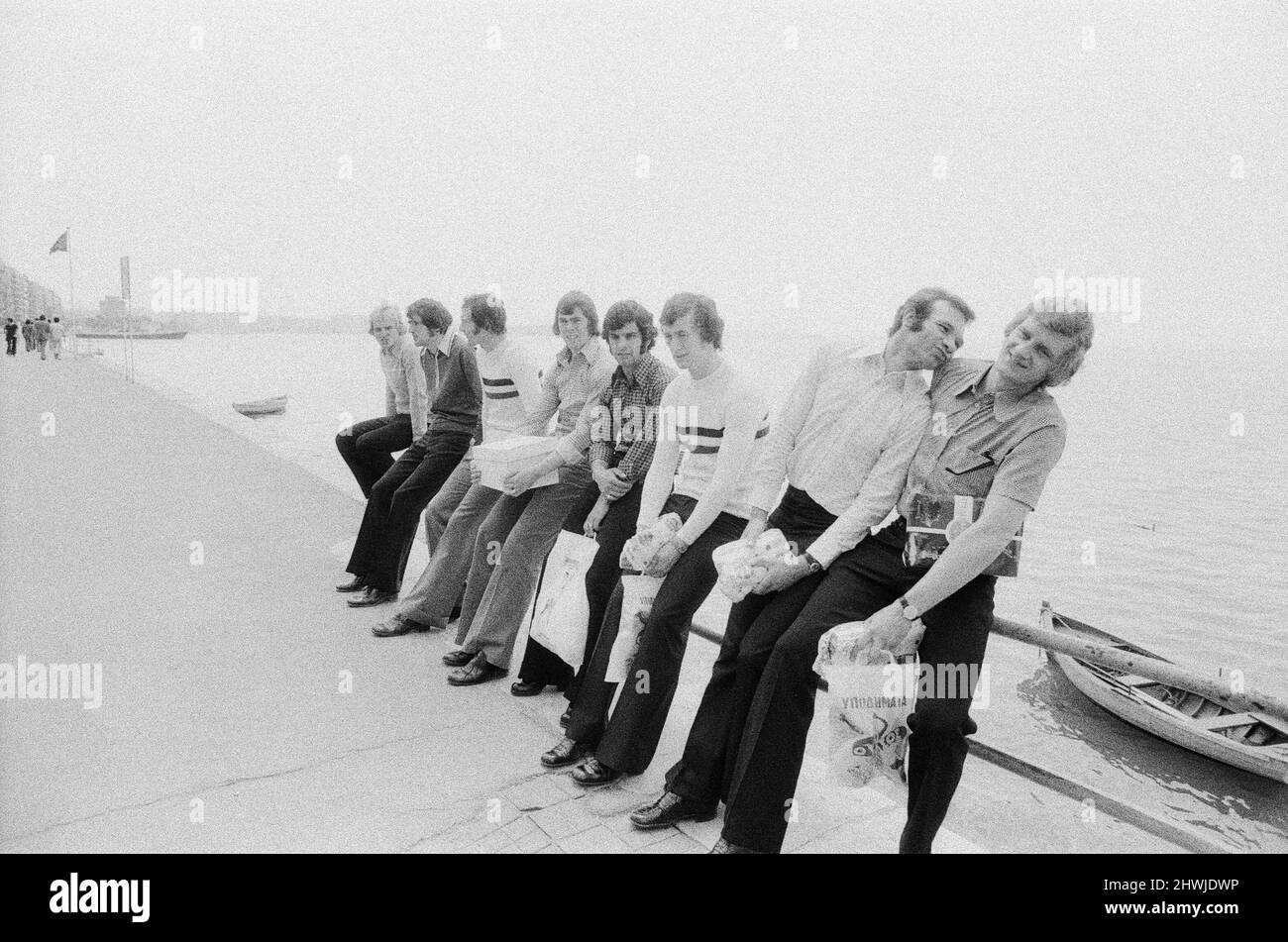 Die Spieler von Leeds United sitzen auf einem Geländer an der Promenade, während sie einen Spaziergang durch die Stadt Salonike Unternehmen, bevor sie ihr Finale des European Cup Winners Cup 1973 gegen AC Mailand im Kaftanzoglio Stadium in Thessaloniki, Griechenland, antreten. Leeds verlor 0-1 im Finale nach einigen umstrittenen Entscheidungen des griechischen Schiedsrichters Christos Michas. 15. Mai 1973. Stockfoto