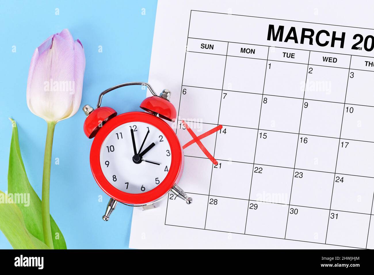 Konzept für die Zeitumstellung für die Sommerzeit in den Vereinigten Staaten am 13.. März mit rotem Wecker und Kalenderblatt mit rot markierter Datumsangabe auf BL Stockfoto